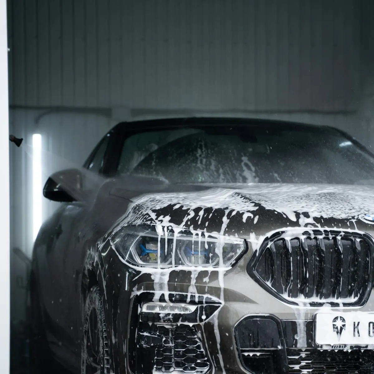 The front of a car covered in wash foam