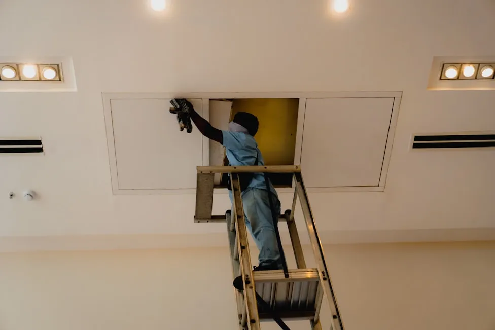 A Bright Line painter cutting in a ceiling line
