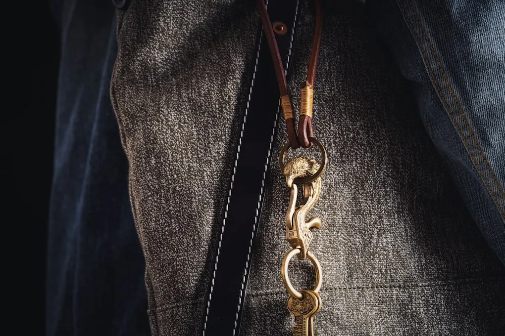 Waxed canvas leads and brass-hardware collars hanging on a peg rail in the shop