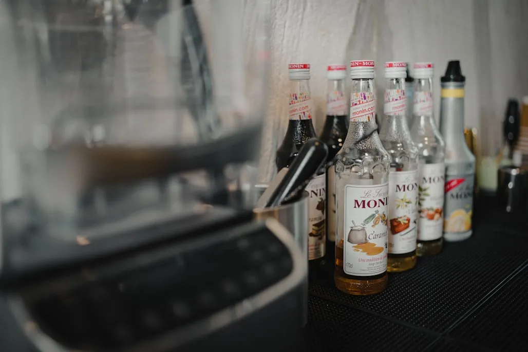 House syrup bottles with handwritten labels on the back counter